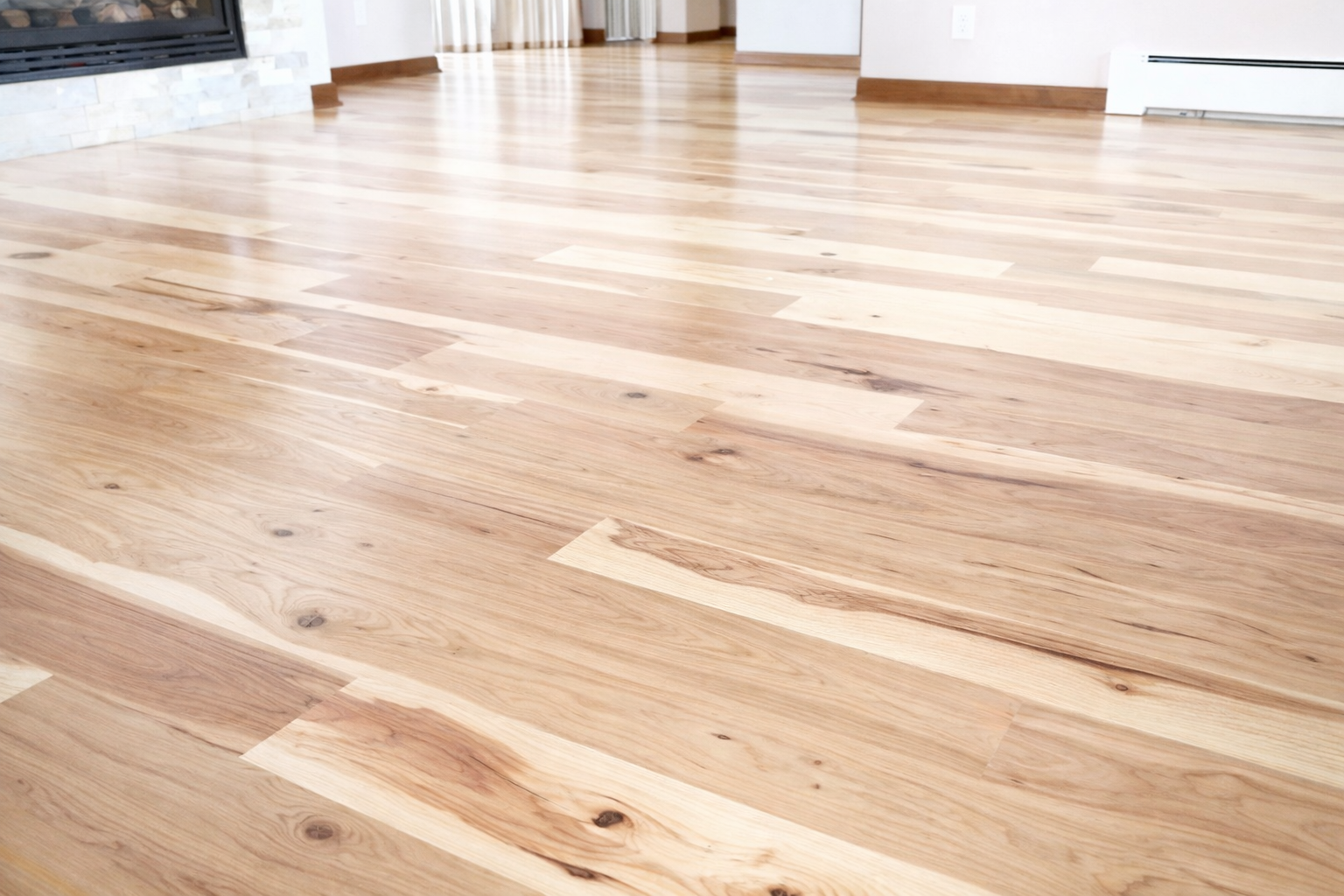 Light-toned hardwood flooring with natural grain variation and subtle knots, professionally installed by Floor Crafters – South Charlotte in a bright open living space.